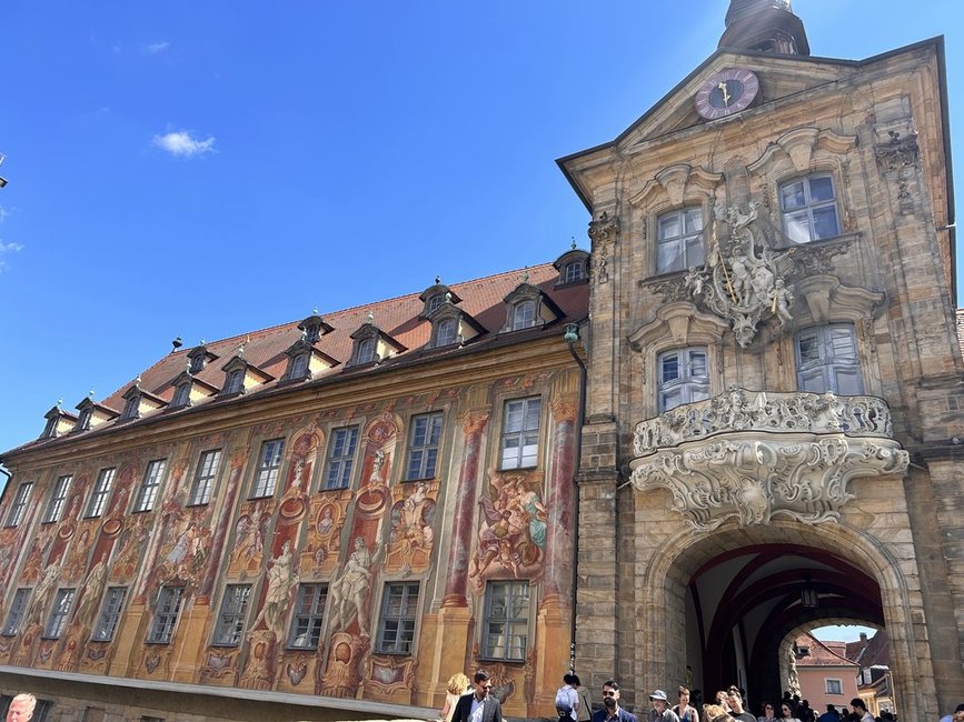Historic building in Bamberg, Germany, featuring ornate murals and intricate architectural details under a clear blue sky.